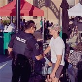 Police officer speaking with a young person at an outdoor community event