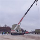photo of contruction site with tall crane and base of water tower beginning to go vertical