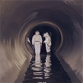 Two workers pictured inside the large-diameter sewer