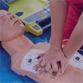 hands performing chest compressions on mannequin with AED chest patches on