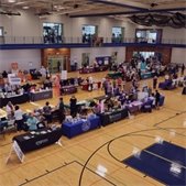 photo of senior fair booths in gymnasium and seniors walking around from last year's event