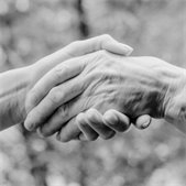 black and white photo of two elderly hands with wrinkles shaking hands
