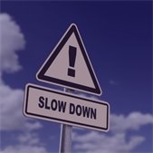 graphic with slow down traffic sign and blue sky and white clouds in background