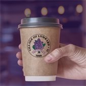 Hand holding a coffee cup with the Village of Lombard seal
