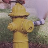 photo of yellow hydrant with water spraying