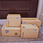 Stack of delivered cardboard packages sitting on a front doorstep
