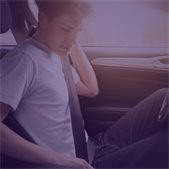 A teen sits in the driver’s seat of a car, fastening their seat belt. The image promotes National Teen Driver Safety Week and encourages safe driving habits among young drivers.