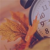 clock with fall leaves in background