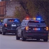 two black lombard police squads with emergency lights activated. 