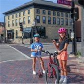 photo of two girls wearing a helmet and holding up their challenge coin