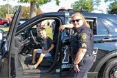 female police officer with child sitting in squad car
