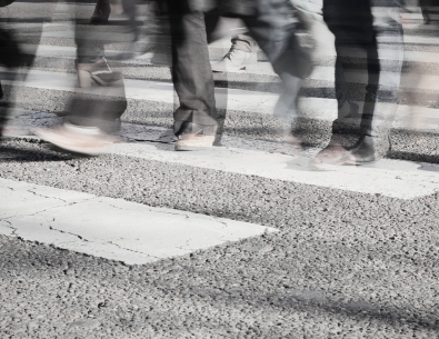 photo of crosswalk with peoples legs and feet walking across 