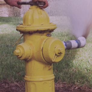 close up of yellow hydrant spraying water out