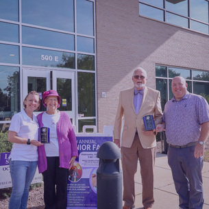photo of trustee and village president presenting award to senior woman and man of the year