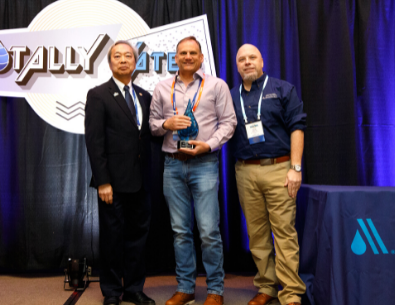 Lombard staff member holding award at event with two men on either side 