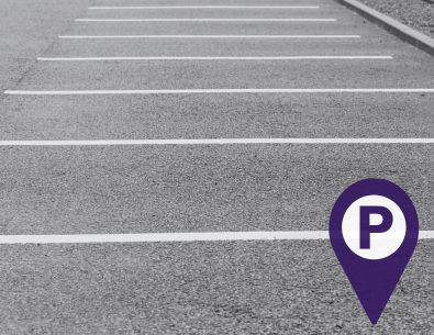 parking spaces in concrete lot with parking symbol in purple 