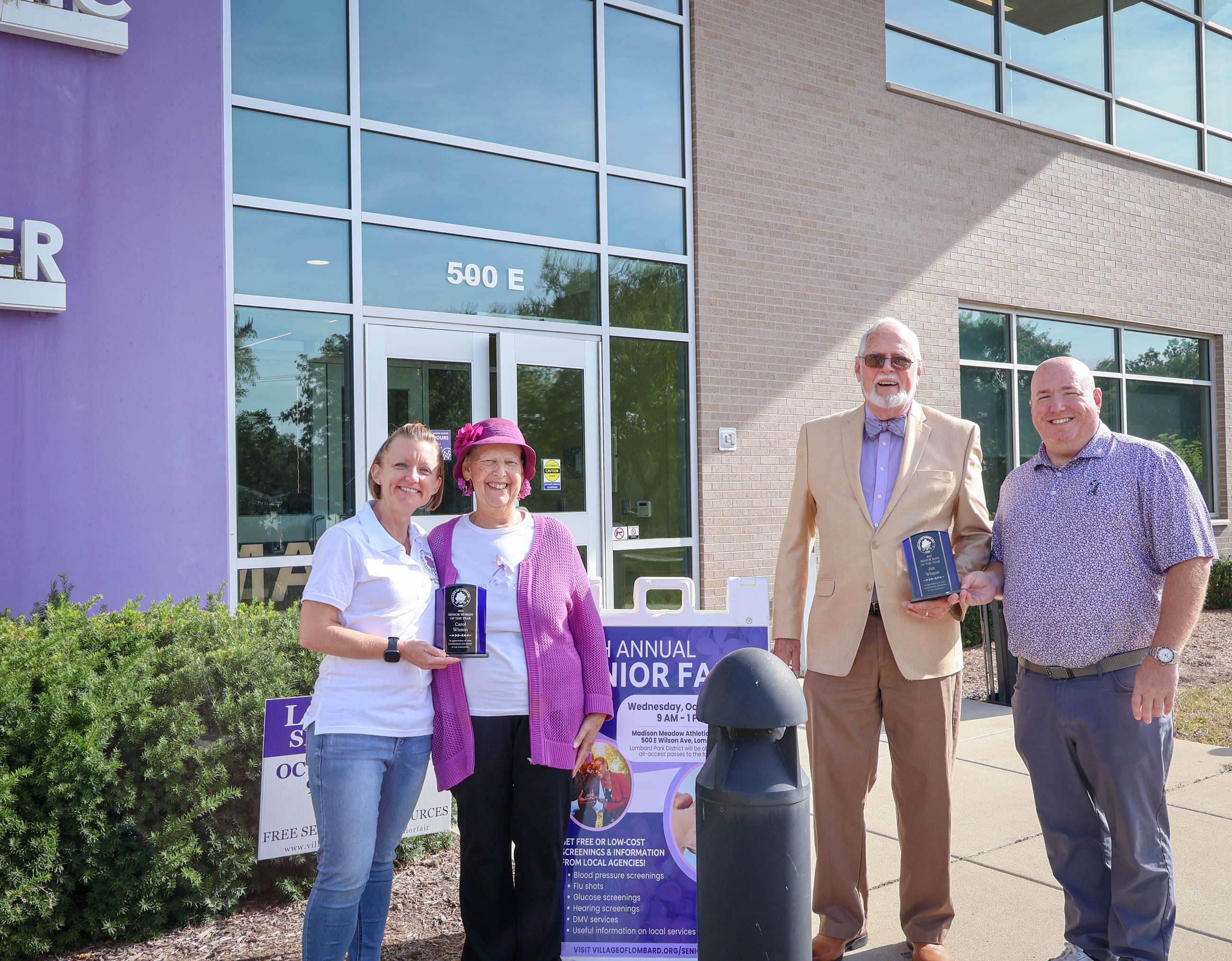 photo of trustee and village president presenting award to senior woman and man of the year