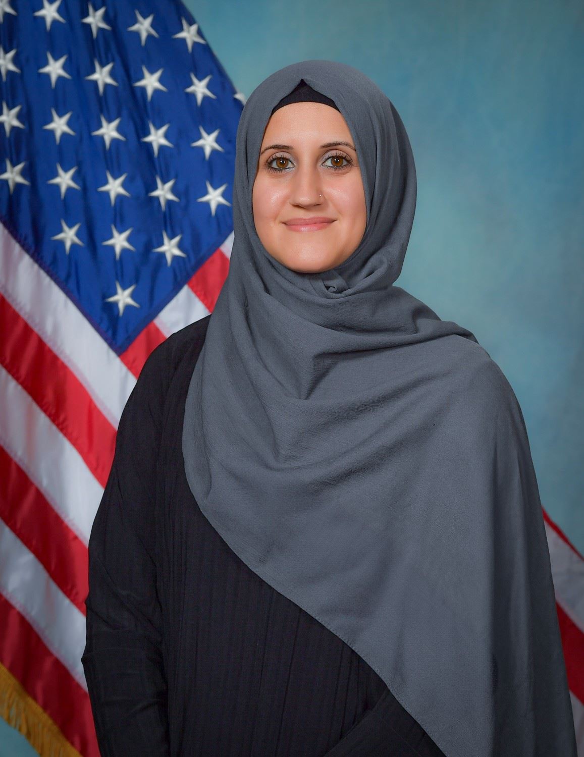 Headshot of Village Clerk Ranya Elkhatib with US flag in background