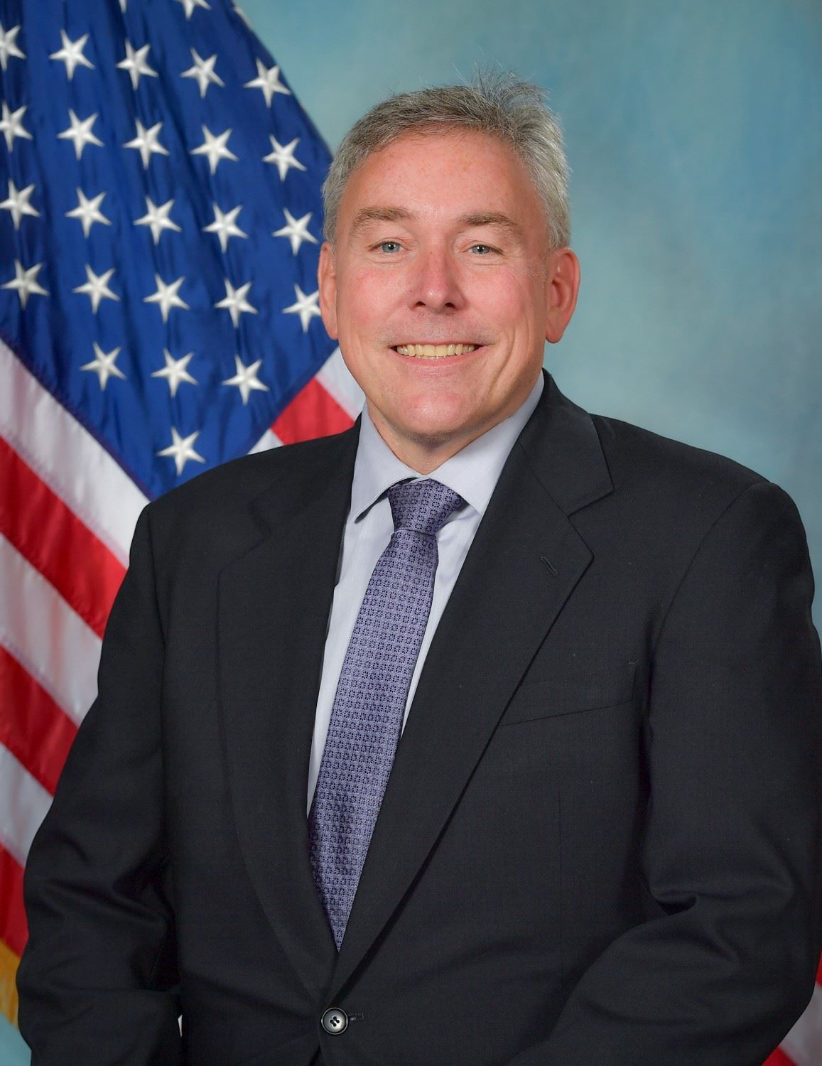 Headshot of Trustee Bernie Dudek with US flag in background