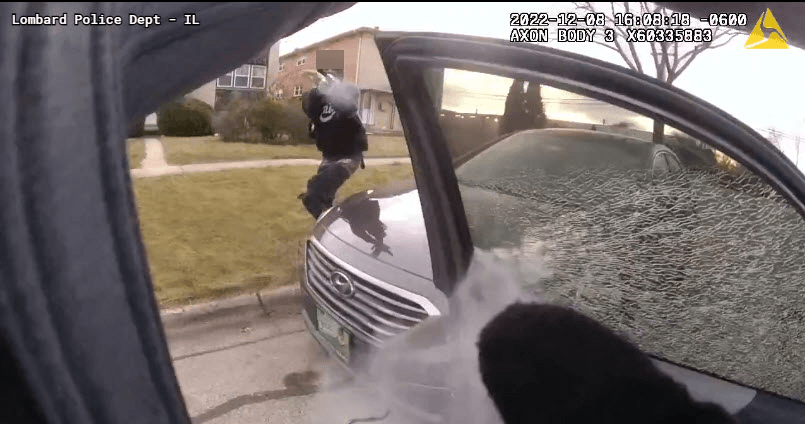 Screenshot of officer body camera footage as suspect discharges weapon at law enforcement